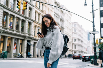 Woman standing on street and texting on mobile phone