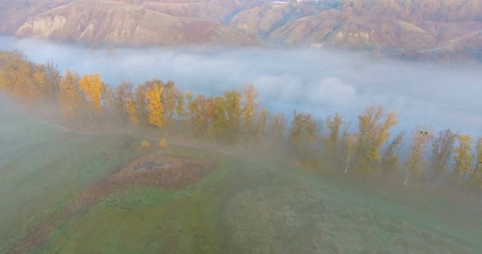 Aerial view of river under morning fog and golden hills, Ukraine