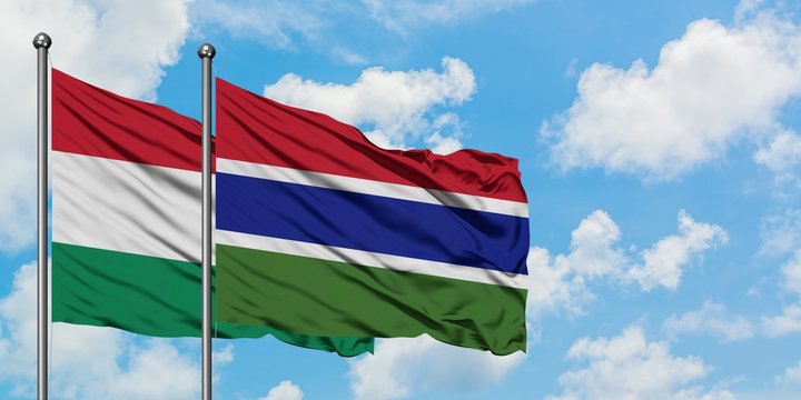 Hungary and Gambia flag waving in the wind against white cloudy blue sky together. Diplomacy concept, international relations.