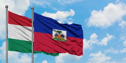 Hungary and Haiti flag waving in the wind against white cloudy blue sky together. Diplomacy concept, international relations.