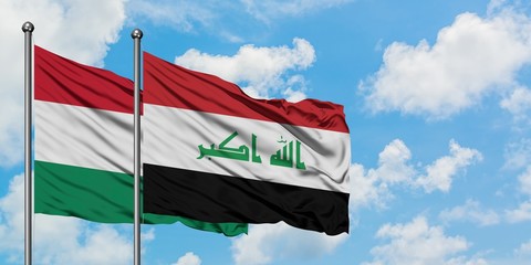 Hungary and Iraq flag waving in the wind against white cloudy blue sky together. Diplomacy concept, international relations.