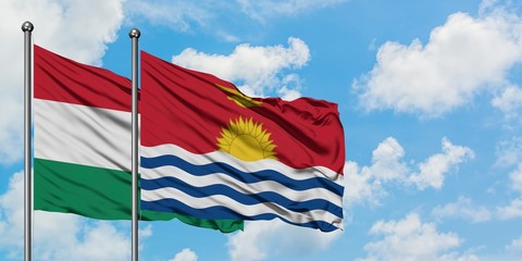 Hungary and Kiribati flag waving in the wind against white cloudy blue sky together. Diplomacy concept, international relations.