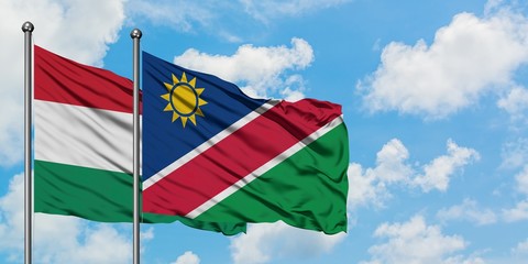Hungary and Namibia flag waving in the wind against white cloudy blue sky together. Diplomacy concept, international relations.