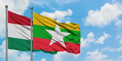 Hungary and Myanmar flag waving in the wind against white cloudy blue sky together. Diplomacy concept, international relations.