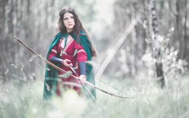 An elf archer with a bow in the woods