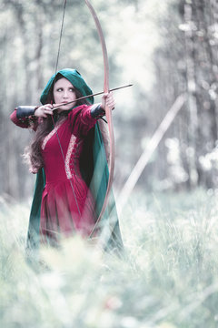 An elf archer with a bow in the woods