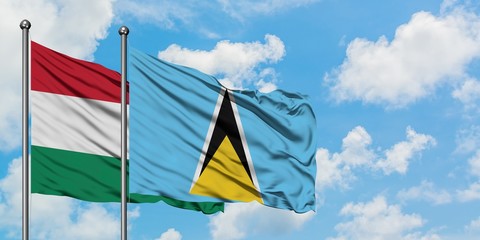 Hungary and Saint Lucia flag waving in the wind against white cloudy blue sky together. Diplomacy concept, international relations.