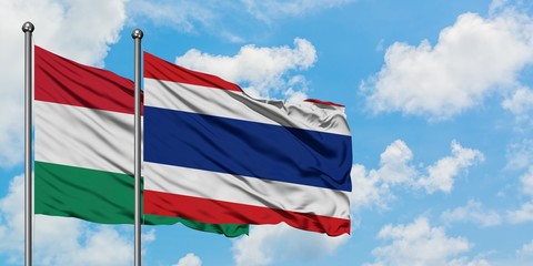 Hungary and Thailand flag waving in the wind against white cloudy blue sky together. Diplomacy concept, international relations.