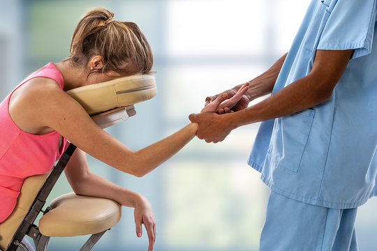 Woman Getting Mobile Chair Massage By Man In Office By A Physiotherapist