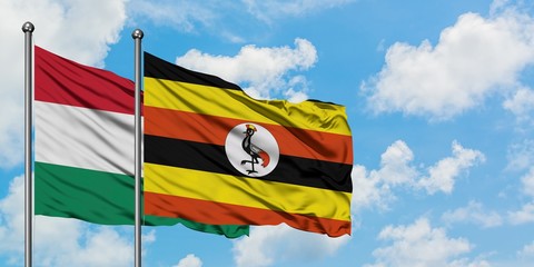 Hungary and Uganda flag waving in the wind against white cloudy blue sky together. Diplomacy concept, international relations.