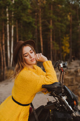 Fototapeta premium Woman on a cross-country motorcycle in a forest near a cliff in the autumn season