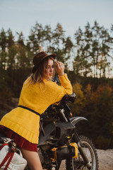 Fototapeta na wymiar Woman on a cross-country motorcycle in a forest near a cliff in the autumn season