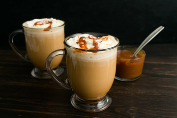 Coffee with milk topped with whipped cream and caramel sauce
