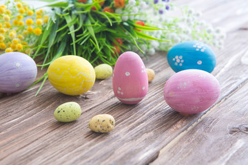 Fototapeta na wymiar Colorful easter eggs with flowers on wooden board