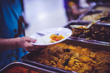 Refugees' hands are receiving food from philanthropists: the concept of hunger problems for the poor