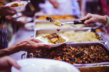 Refugees' hands are receiving food from philanthropists: the concept of hunger problems for the poor