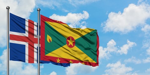 Iceland and Grenada flag waving in the wind against white cloudy blue sky together. Diplomacy concept, international relations.