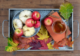 Tray with cozy cup of hot tea and cinnamon on rustic wood table