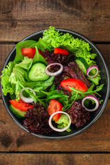 Healthy salad, leaves mix salad (mix micro greens, cucumber, tomato, onion, other ingredients). food background. copy space