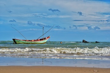 Fishing boat floating in the sea with blue sky