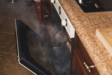 White steam comes from an open oven