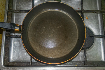 Fototapeta na wymiar Non-stick frying pan on stainless steel gas stove. Home cooking.