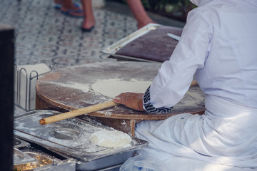 Turkish woman makes a traditional national dish - a baked flat pancake Gozleme.