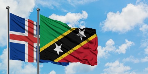 Iceland and Saint Kitts And Nevis flag waving in the wind against white cloudy blue sky together. Diplomacy concept, international relations.