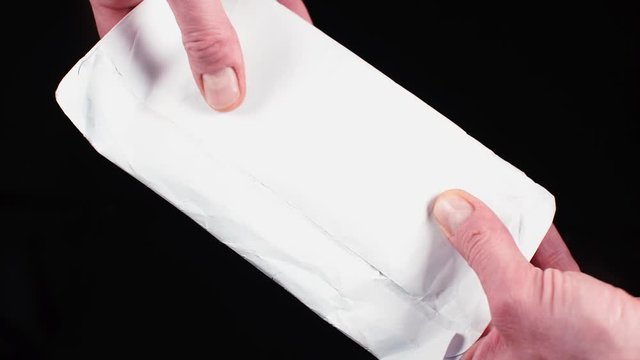 Hand-to-hand transfer of a white envelope