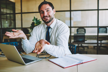 Simply a simple, portrait of smiling office worker rolled his hands cope with the work. An easy way to organize your work. Experienced and professional male employer at workplace with laptop computer