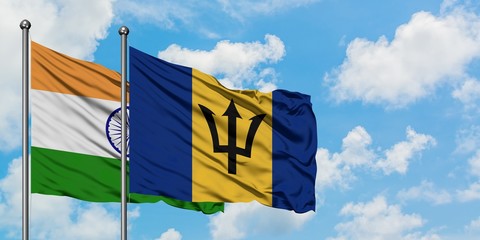 India and Barbados flag waving in the wind against white cloudy blue sky together. Diplomacy concept, international relations.