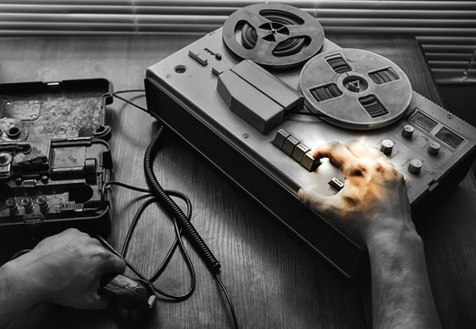 Special agent holds field telephone set USSR. Officer wiretapping   on the reel tape recorder. KGB spying conversations.