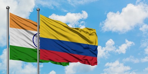 India and Colombia flag waving in the wind against white cloudy blue sky together. Diplomacy concept, international relations.