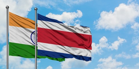 India and Costa Rica flag waving in the wind against white cloudy blue sky together. Diplomacy concept, international relations.