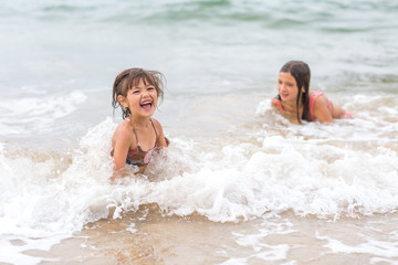 Two young girls playing in the Pacific Ocean