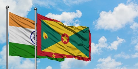 India and Grenada flag waving in the wind against white cloudy blue sky together. Diplomacy concept, international relations.