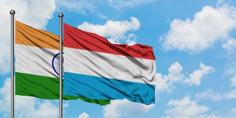 India and Luxembourg flag waving in the wind against white cloudy blue sky together. Diplomacy concept, international relations.