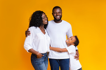 Portrait of happy millennial african american family over yellow background