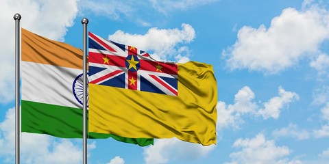 India and Niue flag waving in the wind against white cloudy blue sky together. Diplomacy concept, international relations.