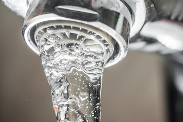 Frozen water stream from a tap Close-up. Aerator operation for saving water consumption.
