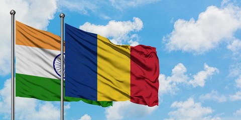India and Romania flag waving in the wind against white cloudy blue sky together. Diplomacy concept, international relations.