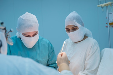 operational team. Girl surgeon looking at the camera during an operation. Conditions for a sterile...
