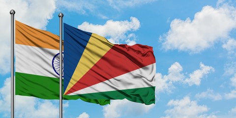 India and Seychelles flag waving in the wind against white cloudy blue sky together. Diplomacy concept, international relations.