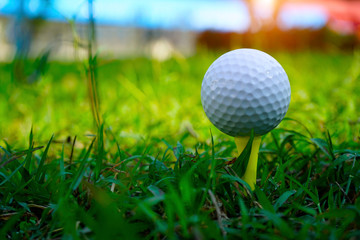 Golf ball on tee in beautiful golf course.