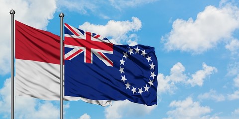 Iraq and Cook Islands flag waving in the wind against white cloudy blue sky together. Diplomacy concept, international relations.