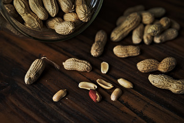 Close up of peanuts in a jar on rustic wooden background