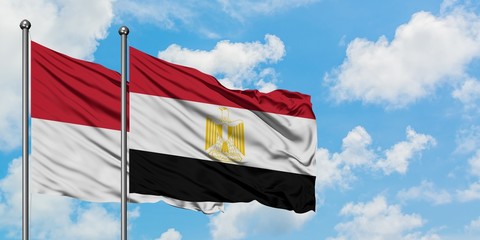 Iraq and Egypt flag waving in the wind against white cloudy blue sky together. Diplomacy concept, international relations.
