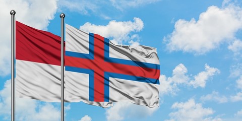 Iraq and Faroe Islands flag waving in the wind against white cloudy blue sky together. Diplomacy concept, international relations.