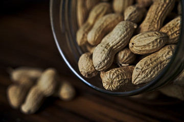 Close up of peanuts in a jar on rustic wooden background