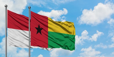 Iraq and Guinea Bissau flag waving in the wind against white cloudy blue sky together. Diplomacy concept, international relations.